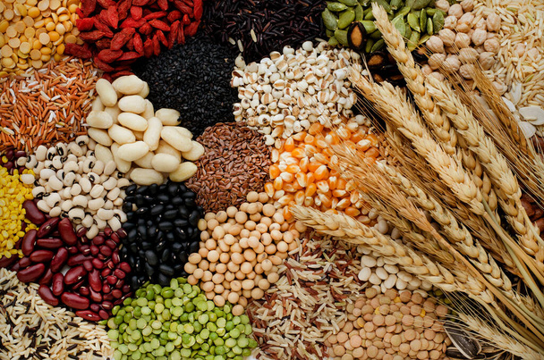 Varietà di cereali biologici secchi e pali di semi di grano con fascio di grano secco in tono scuro, per ingredienti alimentari sani o puliti o concetto di prodotto agricolo - Foto, immagini