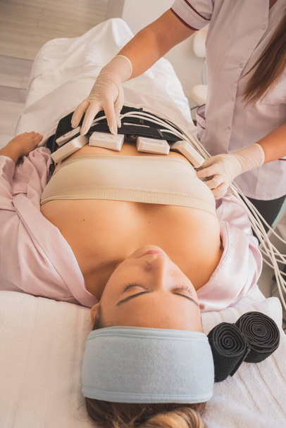 Young Woman enjoying a day at the Spa, to take care of her body. Carrying out different procedures for the reduction of measures. - Photo, Image