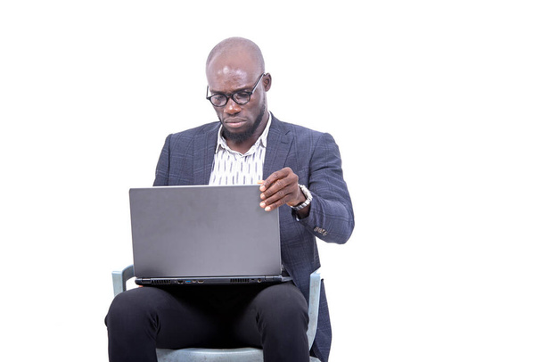 Porträt eines ernsthaften erwachsenen Geschäftsmannes, der auf einem Stuhl sitzt und am Laptop arbeitet. - Foto, Bild