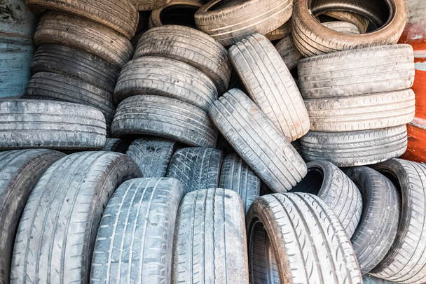 Detail alter und ausgedienter Reifen, aufgetürmt in einer Kläranlage. - Foto, Bild