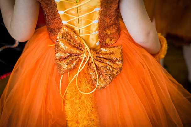 adorable vestido naranja hinchado para una chica de tul, con un enorme arco naranja en la espalda, lentejuelas de plata brillante - Foto, Imagen