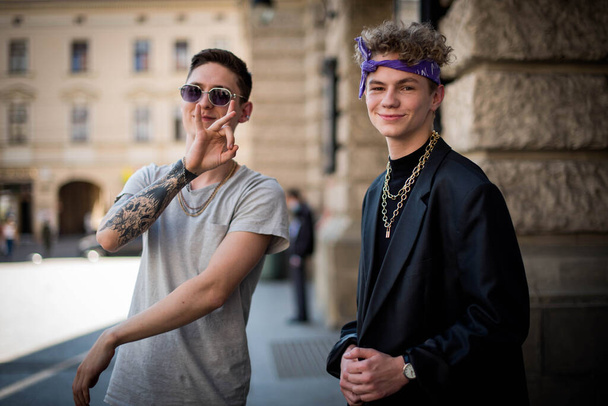 Cute fun curly teenage boy and man wearing stylish 90s fashion clothes with chains around neck. Youth subculture. Rap artist from new school. - Photo, Image