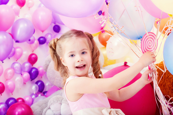 Merry little girl posing with bunch of balloons - Zdjęcie, obraz
