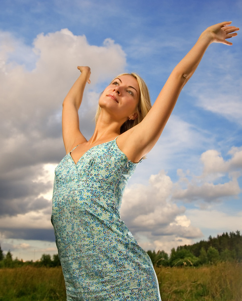 Pretty young woman over blue cloudy sky - Foto, Imagen