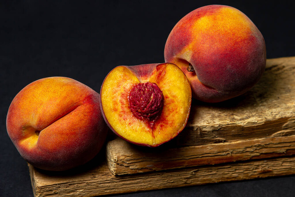 Peaches on a black background. Peach cut in half. Healthy diet. - Photo, Image
