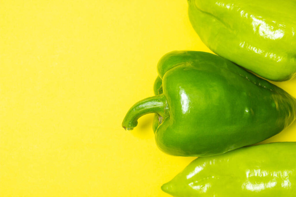Green peppers on a yellow background. Healthy vegetables. Bell pepper - Foto, Imagen