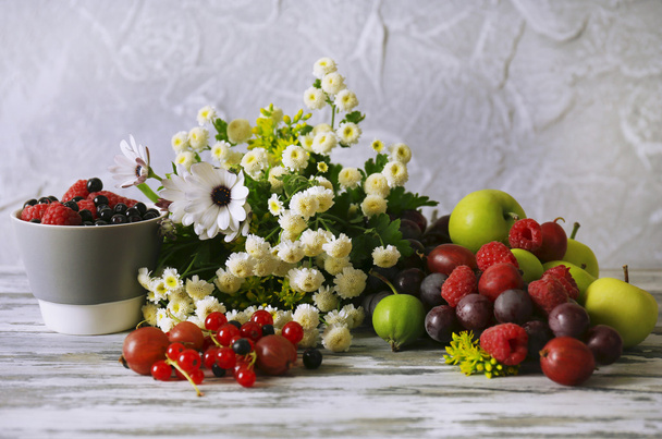 Flowers and berries on wooden table - Foto, imagen
