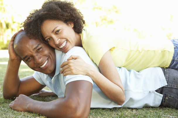 Portrait Of Young Couple Laying On Grass In Park - Photo, image