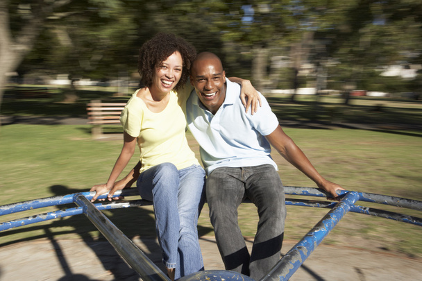 Young Couple Riding On Roundabout In Park - Foto, Bild