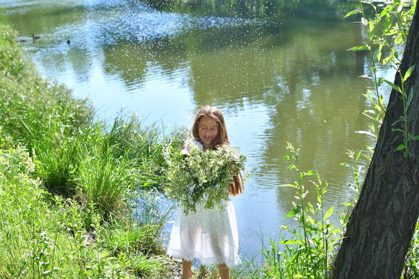 Lány gyönyörű koszorúval a nyári réten, a folyó mellett. Ünnepe Ivan Kupala.Szentiván.Július 7., hagyományos rabszolga ünnep jövendőmondó és jövendölési rituálék Ukrajnában.Szelektív fókusz - Fotó, kép