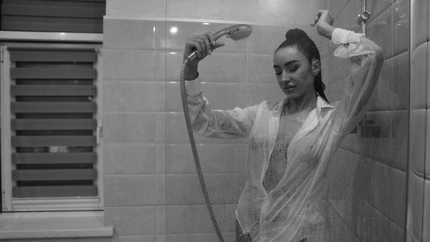όμορφη νεαρή γυναίκα με ανδρικό πουκάμισο που ποζάρει στο μπάνιο, ασπρόμαυρη φωτογραφία - Φωτογραφία, εικόνα