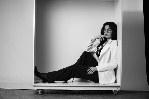 schöne brünette Frau in Dessous und Hosen mit weißem Hemd posiert in Würfel im Studio  - Foto, Bild