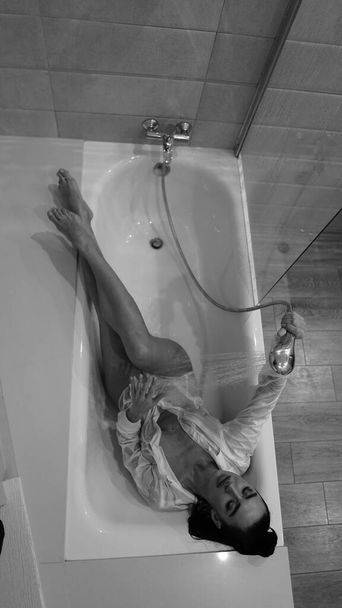 beautiful young woman in male shirt posing in the bathroom, black and white photo - Foto, imagen