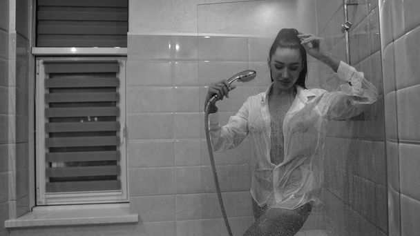 piękna młoda kobieta w męskiej koszuli pozowanie w łazience, czarno-białe zdjęcie - Zdjęcie, obraz