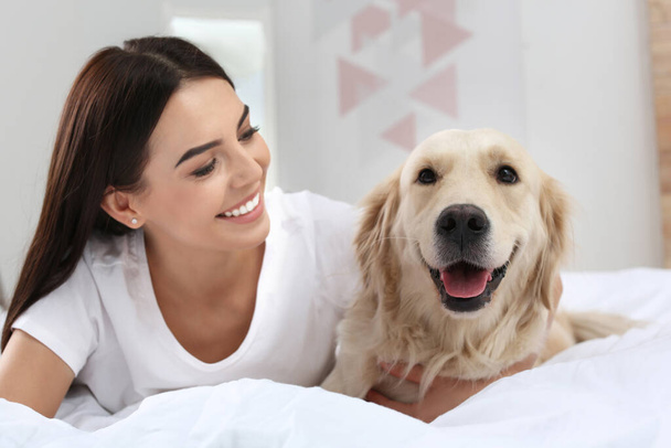 Mujer feliz con su lindo perro mascota en casa - Foto, Imagen