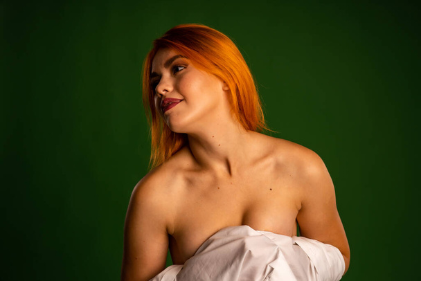 atrakcyjna naga młoda kobieta w białej koszuli i majtki pozowanie na zielonym tle ściany kolor w studio    - Zdjęcie, obraz