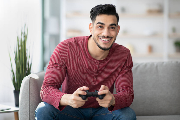 Young arab man playing video games at home - Foto, afbeelding