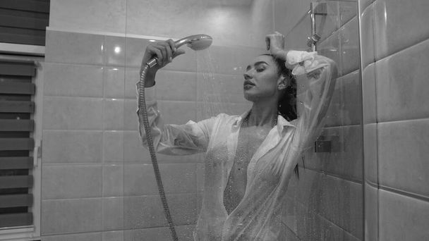 schöne junge Frau in männlichem Hemd posiert im Badezimmer, Schwarz-Weiß-Foto - Foto, Bild