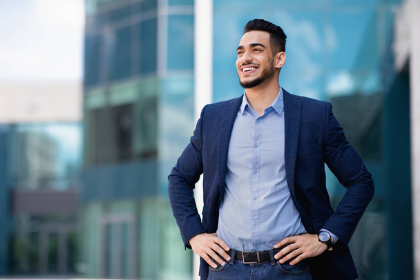 Homme d'affaires joyeux du Moyen-Orient posant par centre de bureau, panorama - Photo, image