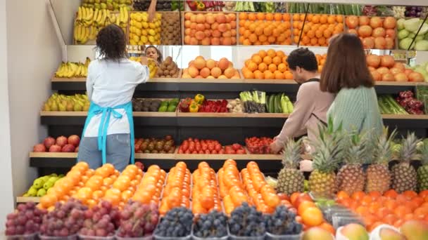 Различные покупатели выбирают овощи в магазине - Кадры, видео