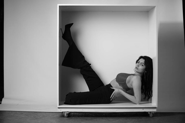 beautiful brunette woman wearing lingerie and pants posing on white studio background - Foto, imagen