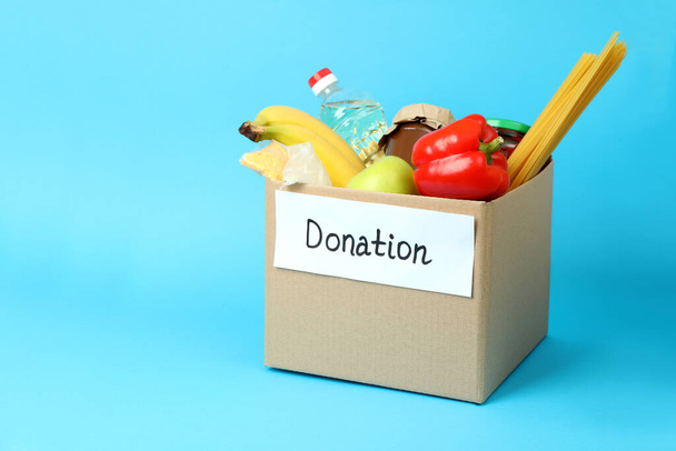 Konzept der Spende mit Spendenbox auf blauem Hintergrund - Foto, Bild