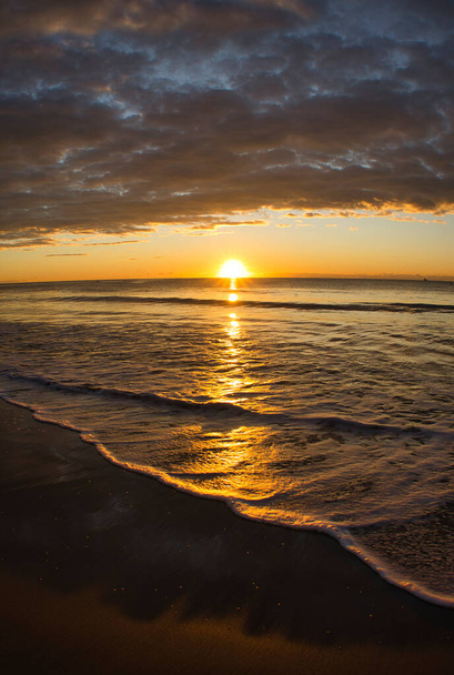 Хмаровий схід сонця на пляжі в Бенікасімі (Іспанія). - Фото, зображення