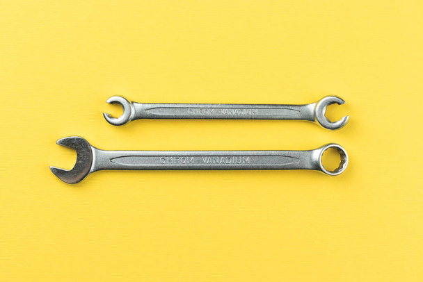 Wrenches on bright yellow background, steel hand work tools - Fotó, kép