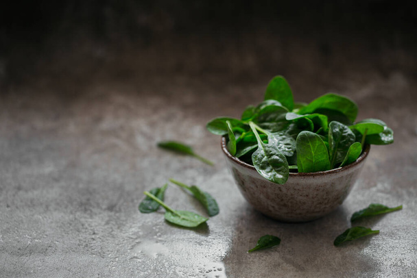 Leaves of fresh baby spinach in a Bowl. - Фото, зображення