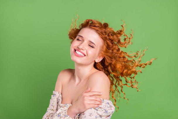 Foto de hermosa joven feliz mujer positiva viento soplo aire primavera aislado sobre fondo de color verde - Foto, Imagen