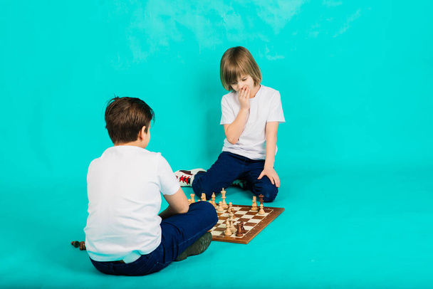 Two boys playing chess, in studio, background - Photo, Image