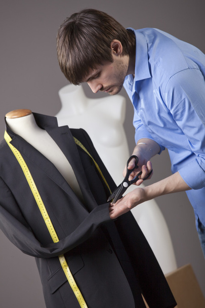 mannelijke kleermaker werken op zakelijke jas met een schaar - Foto, afbeelding