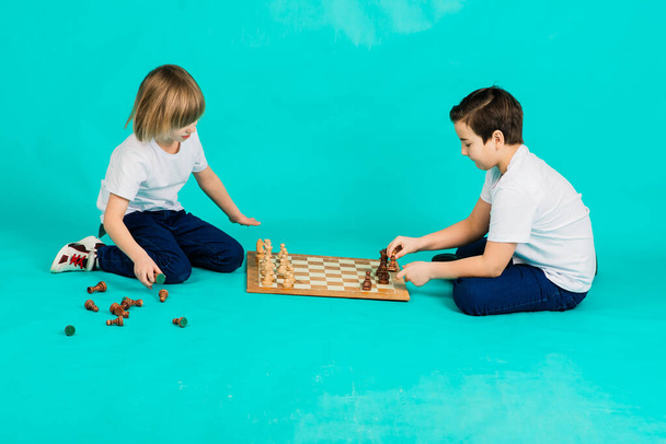 Kaksi poikaa pelaamassa shakkia, studiossa, tausta - Valokuva, kuva