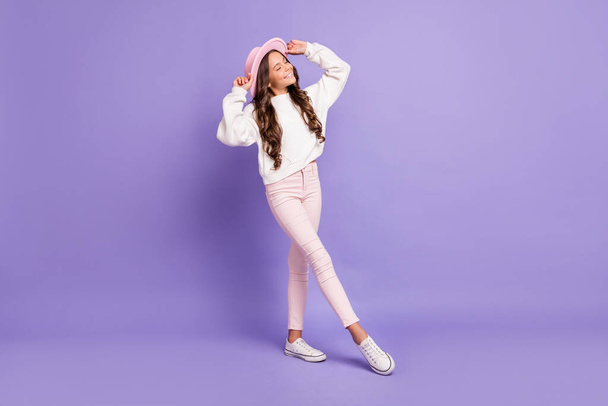 Full length photo of young attractive girl happy positive smile dream dreamy hands touch hat isolated over violet color background - Foto, immagini