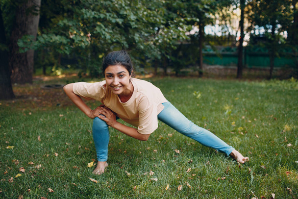 Sporty Millennial Indian Woman in Casual Clothing Stretching Before Training In Park, Doing Warming Up Exercises - Foto, immagini