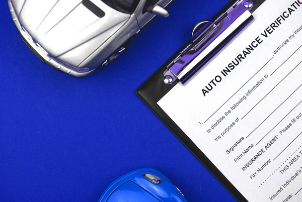 テーブルとオフィスのデスクトップ上の車のおもちゃで自動車保険金請求書フォーム。事故の概念からの保護。トップ表示  - 写真・画像