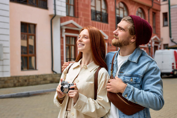 Tourism and technology. Happy young couple taking photo of old town. Traveling by Europe. - Foto, imagen