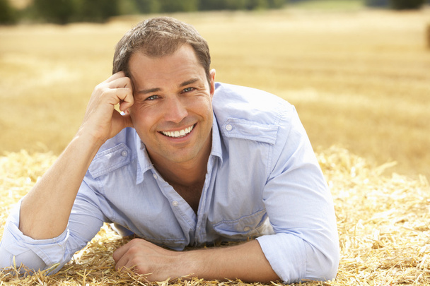 Portrait Of Man Laying In Summer Harvested Field - Foto, immagini