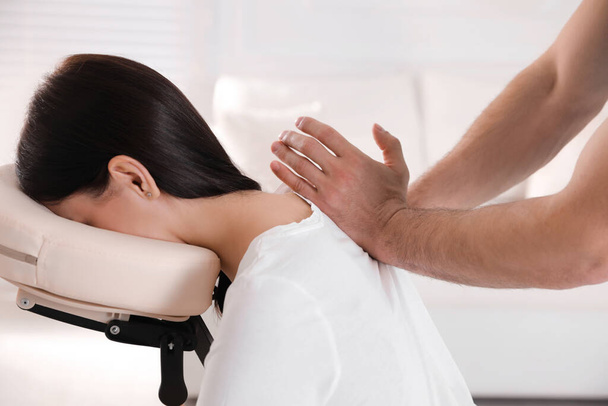 Woman receiving massage in modern chair indoors, closeup - 写真・画像