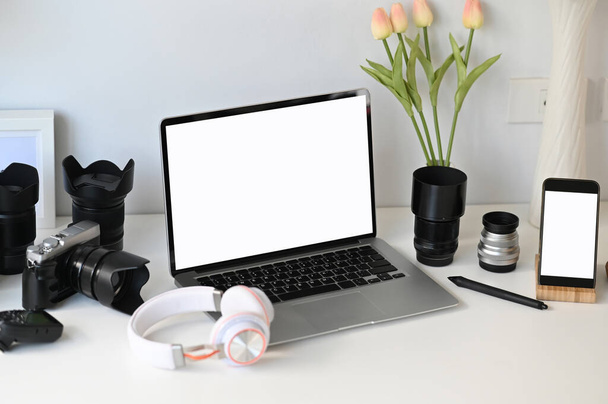 Um laptop aberto com tela branca no espaço de trabalho de designer gráfico ou fotógrafo. - Foto, Imagem