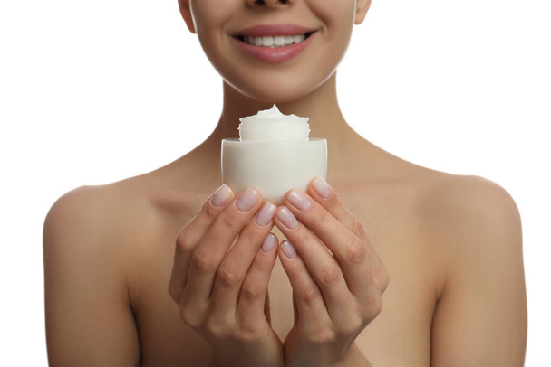 Woman holding jar of facial cream on white background, closeup - Foto, afbeelding