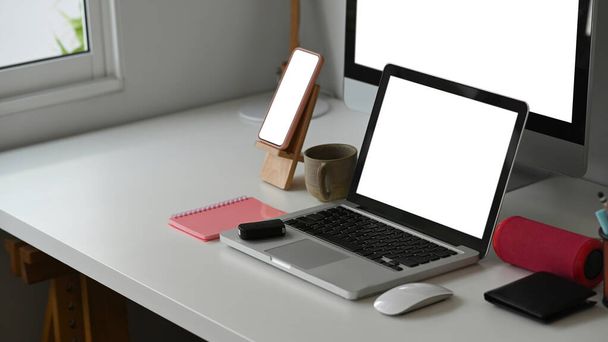 Widok z boku wielu urządzeń wyświetlających dla responsywnej promocji web desing na nowoczesnym biurku. - Zdjęcie, obraz