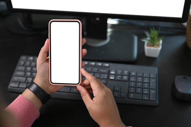 Close up widok kobiety freelancer ręce trzymając telefon komórkowy z pustym ekranem do montażu wyświetlacza graficznego. - Zdjęcie, obraz