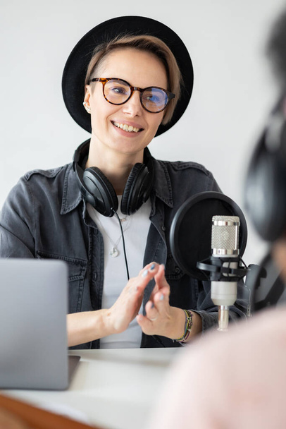 Jovem e confiante mulher europeia gravando um podcast em um estúdio de gravação - Foto, Imagem