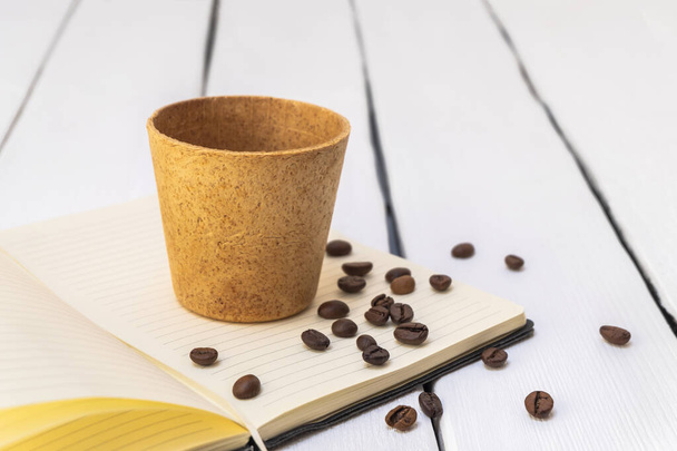 Съедобная чашка кофе с жареными бобами на белом фоне - Фото, изображение