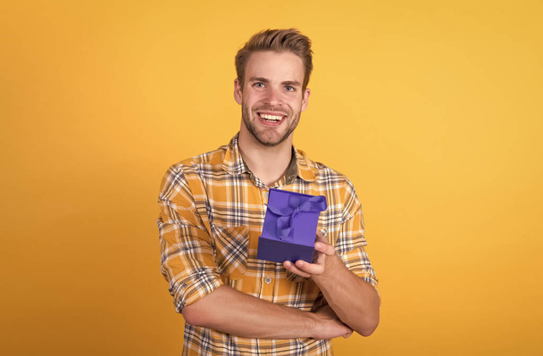 fröhlicher Mann im karierten Hemd hält Geschenkbox für den Urlaub nach dem Einkauf, schwarzer Freitag - Foto, Bild
