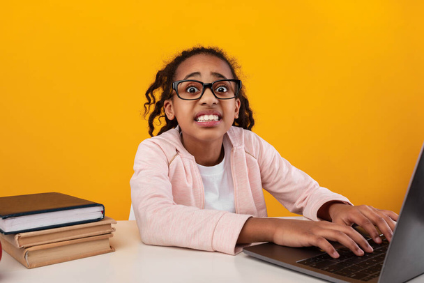 Šokovaný černošky dívka pomocí notebooku a při pohledu na kameru - Fotografie, Obrázek