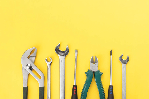Work tools on bright yellow background with copy space. Top view, flat lay - Photo, Image