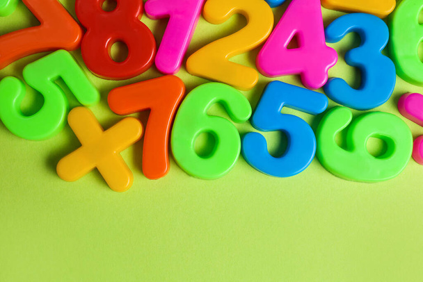 Colorful magnetic numbers on light green background, flat lay - Foto, Imagem