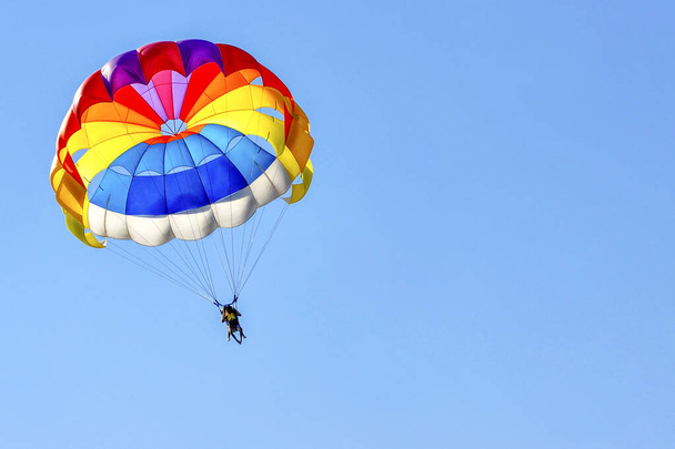 Para sailing using a parachute on background of blue sky. - Valokuva, kuva